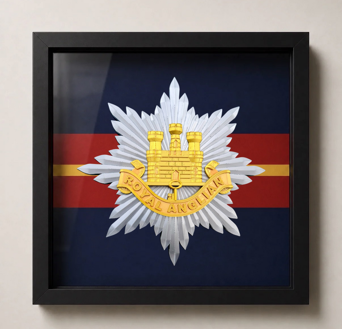 Royal Anglian Regiment cap badge in a deep box display frame with handmade regimental-coloured backing