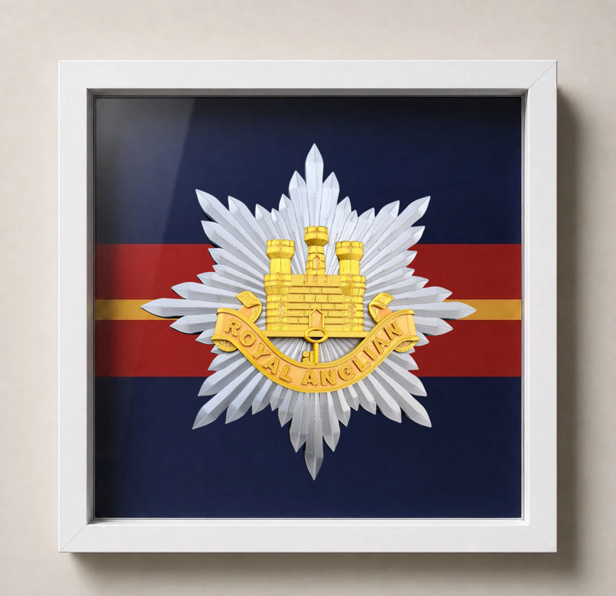 Framed Royal Anglian Regiment cap badge showing the gold Gibraltar Castle and Key on a silver eight-pointed star