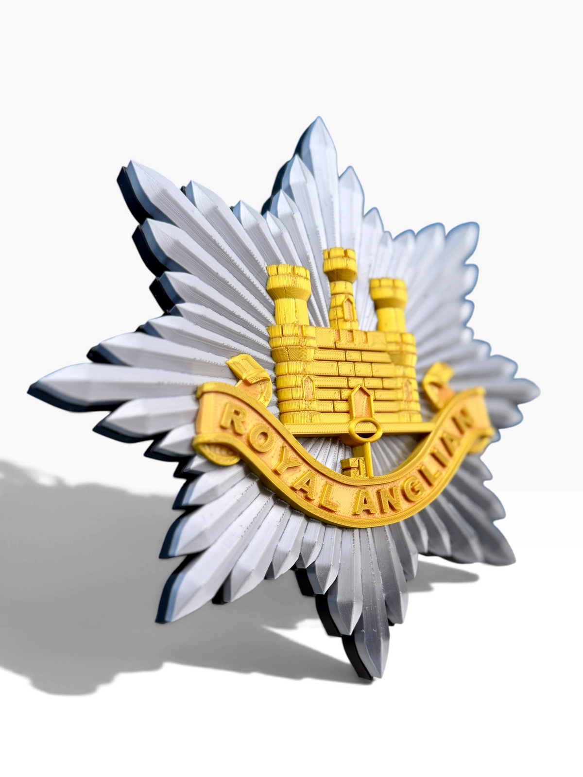 Royal Anglian Regiment cap badge with gold Gibraltar Castle and Key set on a silver eight-pointed star